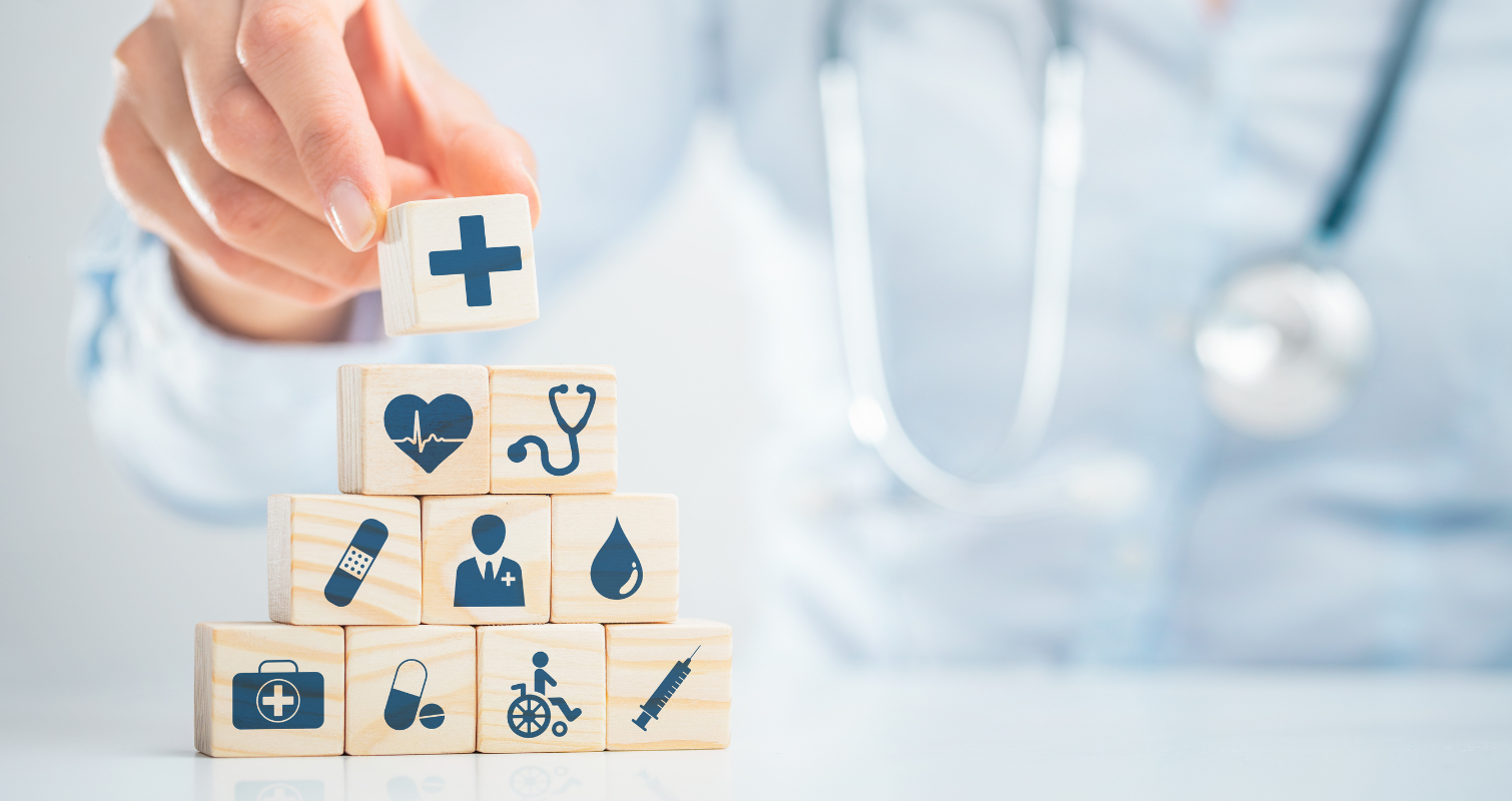 Healthcare related icons printed on wooden blocks being stacked in the shape of pyramid