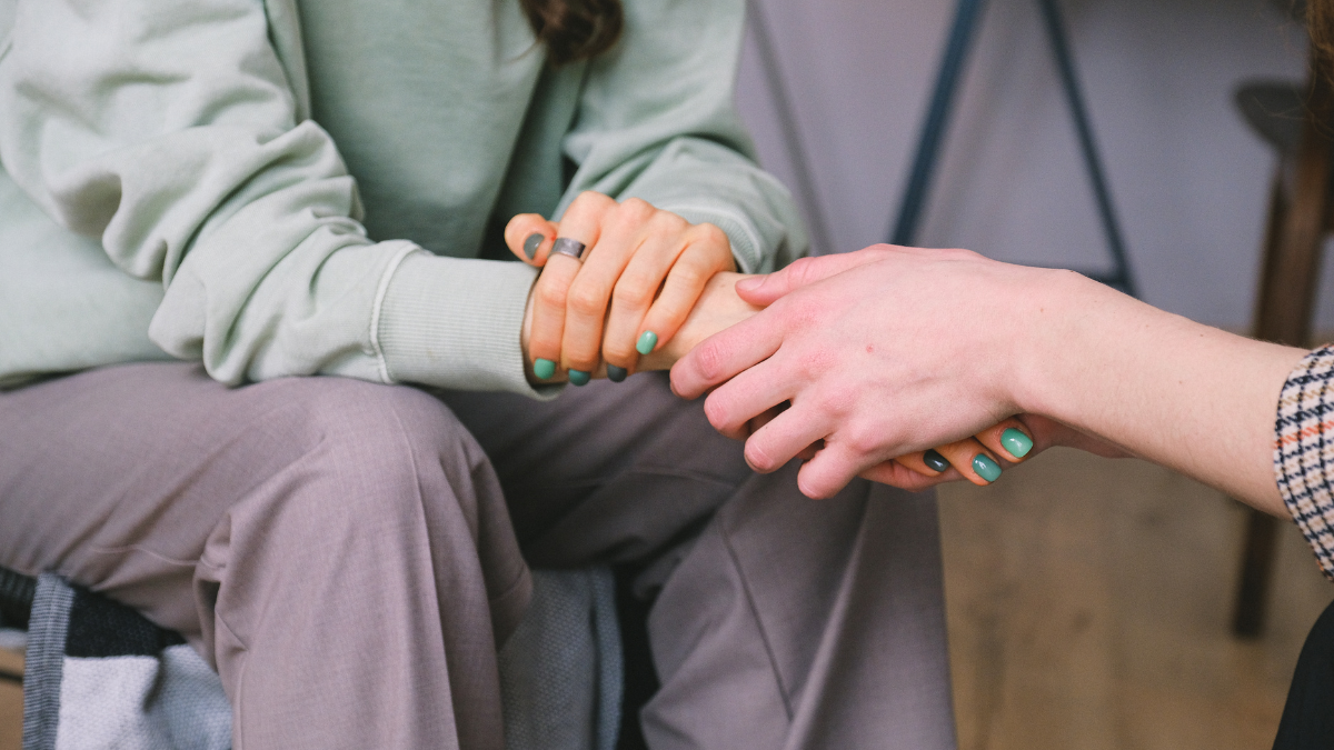person holding someone's hand showing support