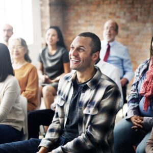 People smiling, sat in a room, classroom