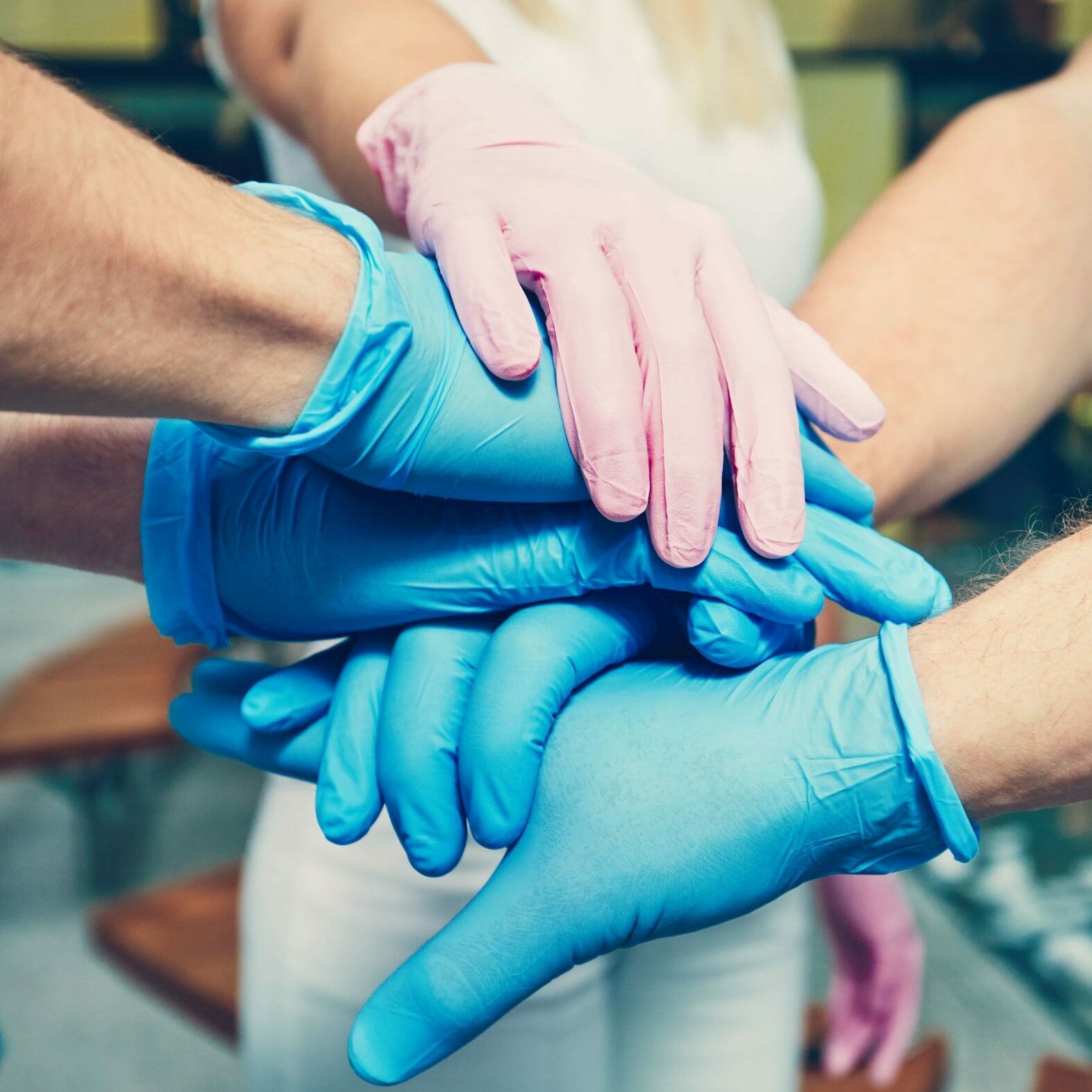 team work, gloved hands on top of each other