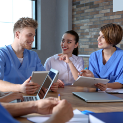 medical professionals meeting, desk with laptops and tablets in front