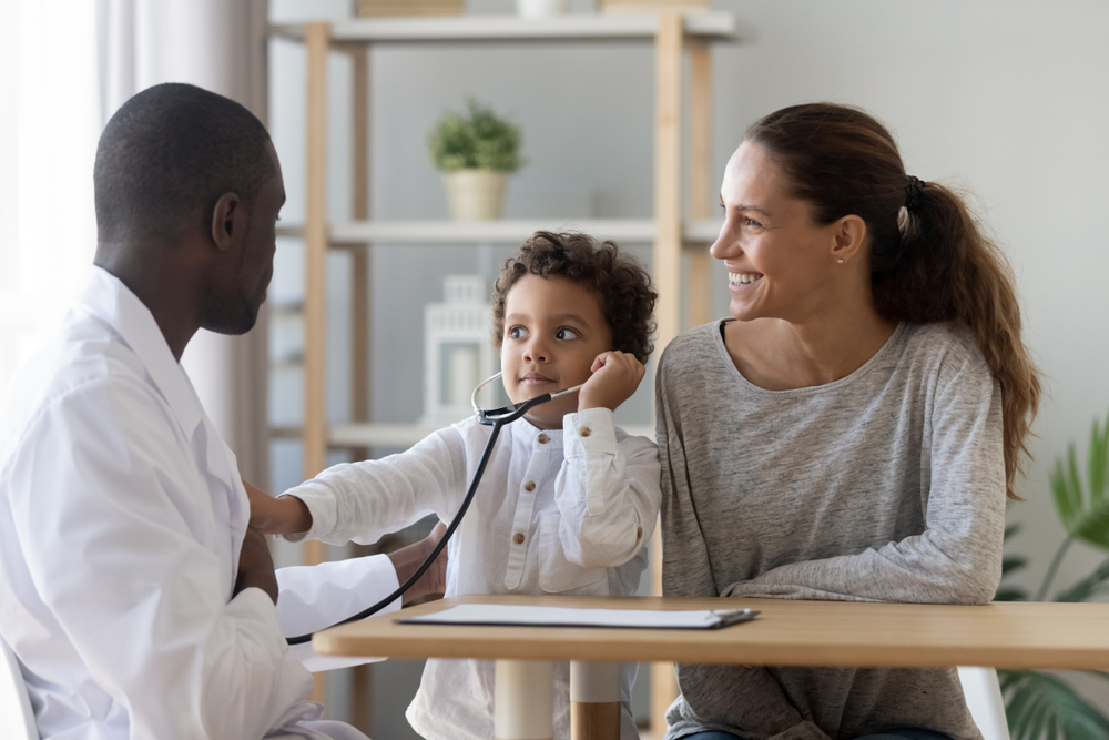 Male Doctor Showing How Phonendoscope Works To Small child