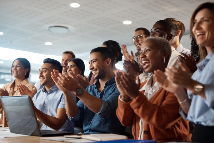 group of people facing the front applauding