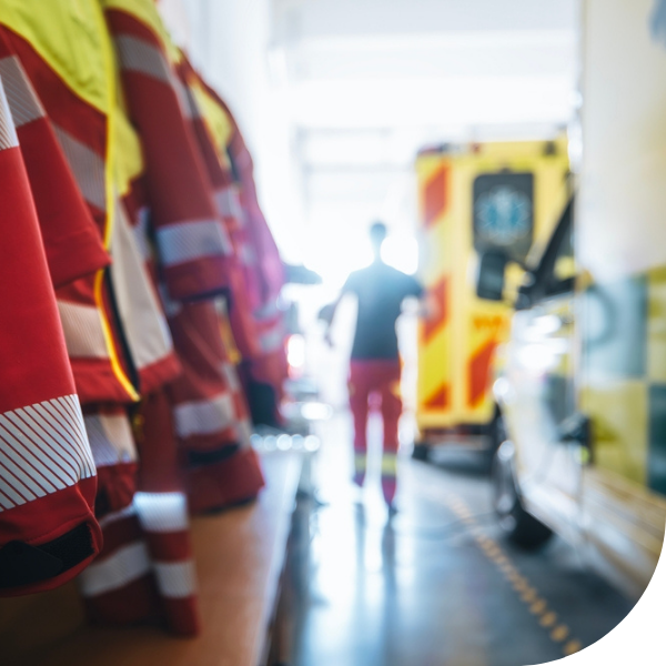 emergency vehicles and person walking along side them with paramedic uniforms hanging