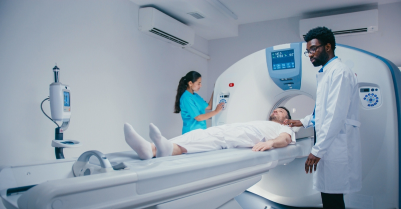 doctor and nurse with a patient lying down going into radio therapy machine