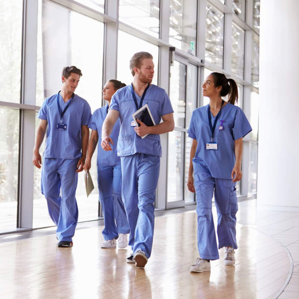 medical staff walking along corridor. Mix of men and women