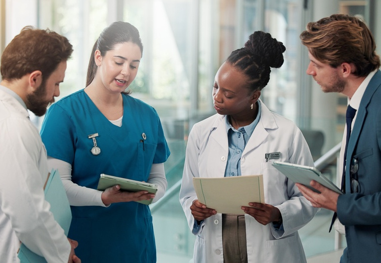 Businessman, doctors and nurse with tablet in clinic for medical admin, patient system or feedback. People, healthcare team and HR manager with tech