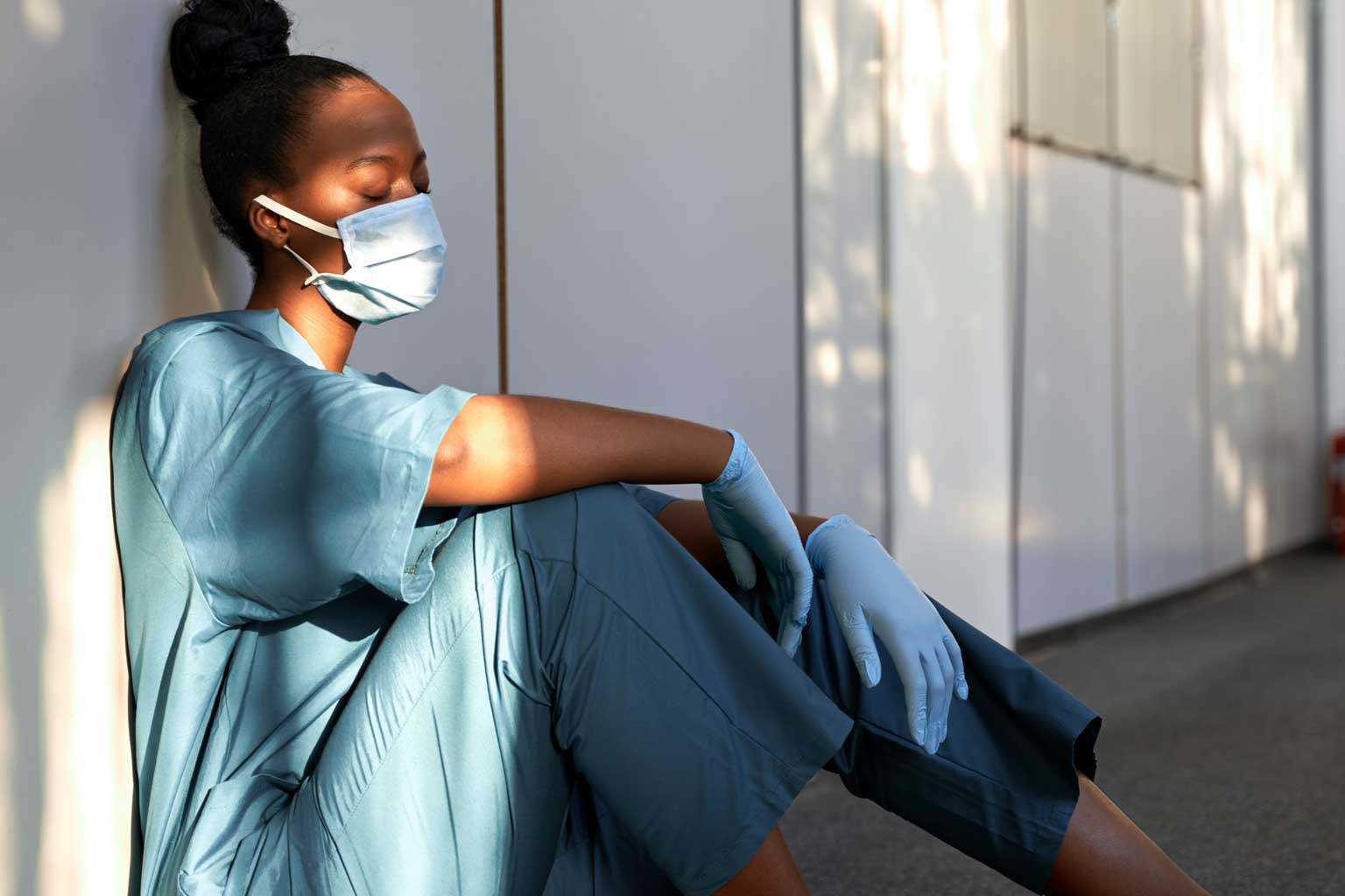 Nurse in mask sat on floor