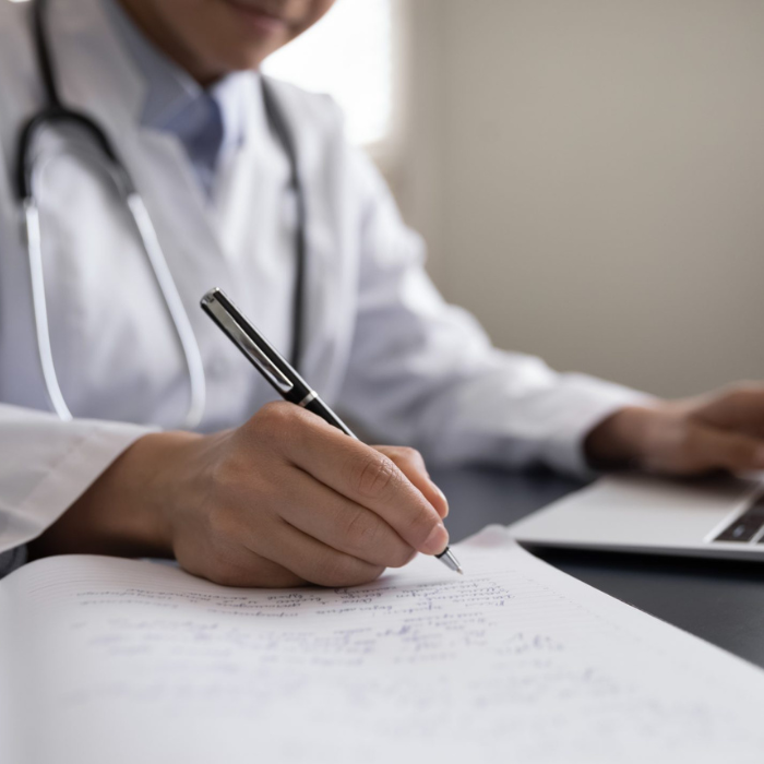 medical professional on computer making notes